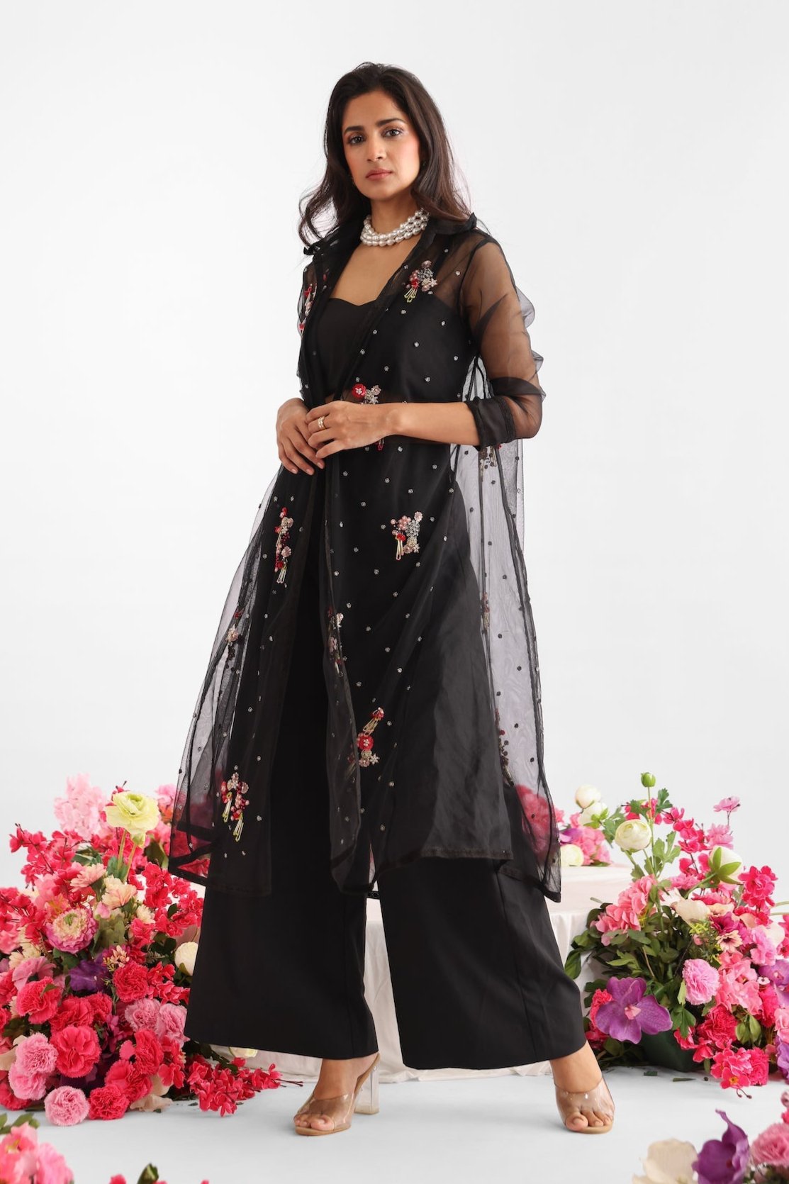Black embroidered net and silk organza jacket with floral motifs, colorful tassels, lace detailing, paired with black bustier and flared pants – Golden Muslin