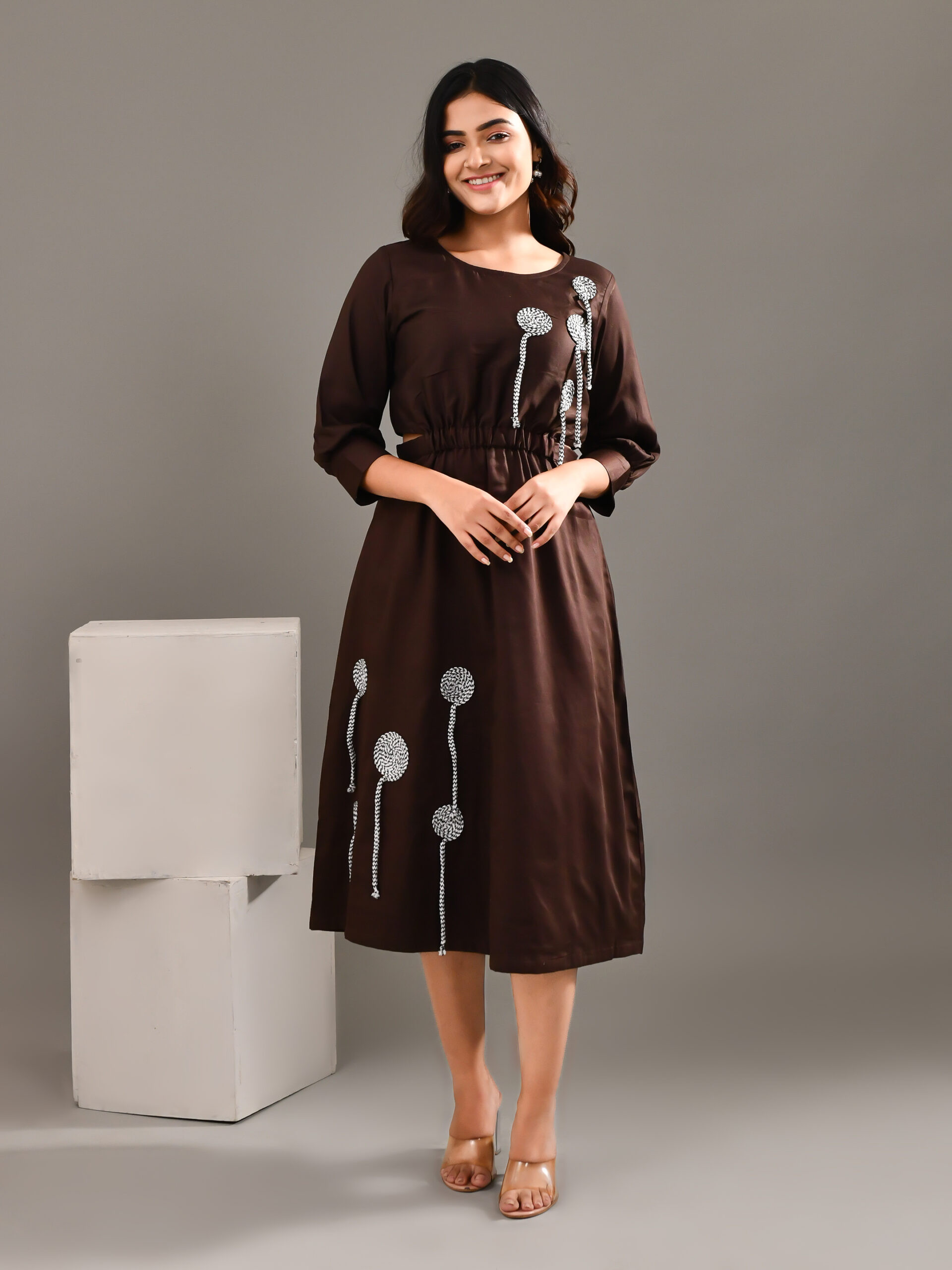 “Golden Muslin dark chocolate brown blended cotton dress with side cut-outs, elasticated gathered yoke, and monochrome cord patchwork detailing.”