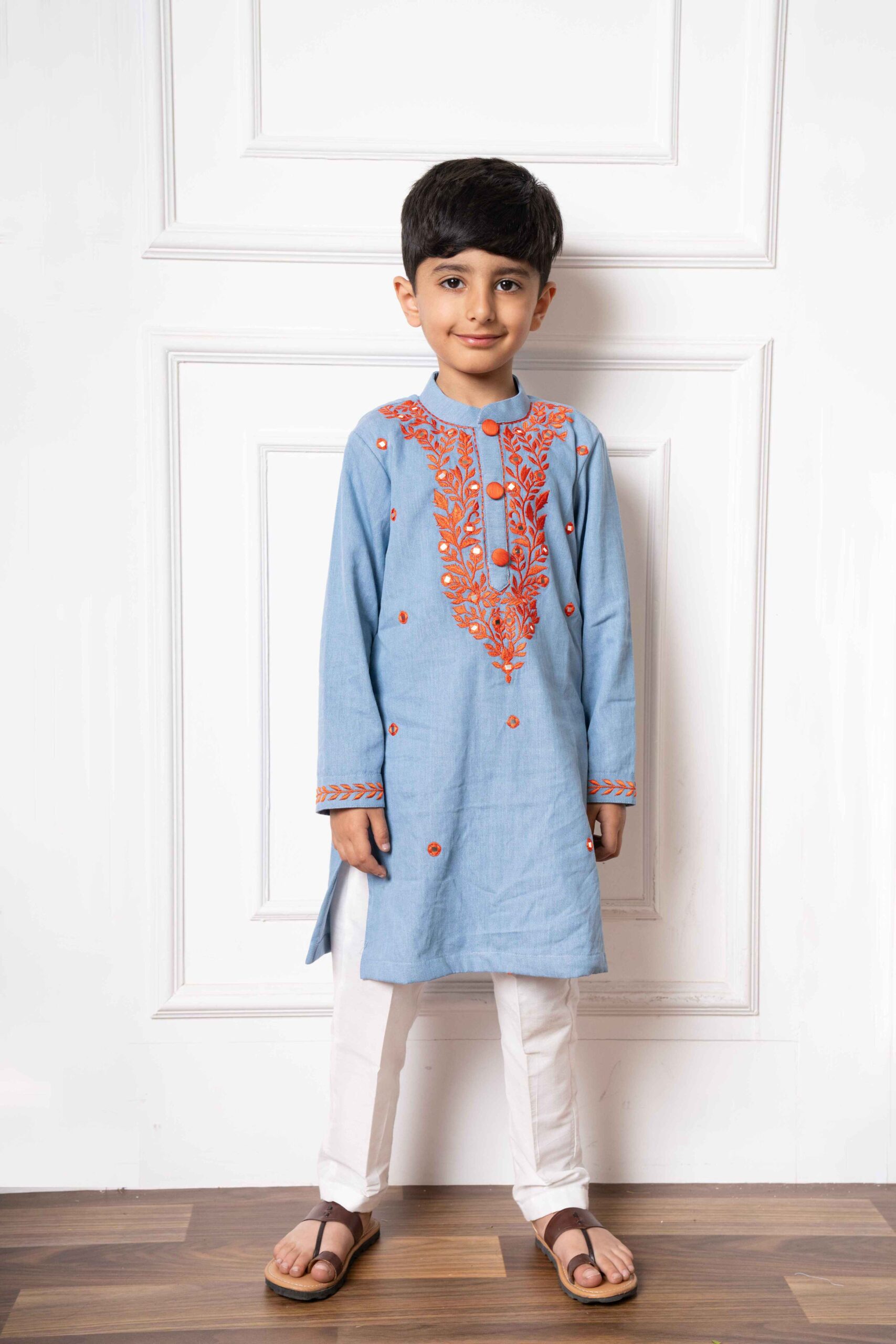 Light blue soft denim kurta with orange floral embroidery and white straight-cut pants – Golden Muslin