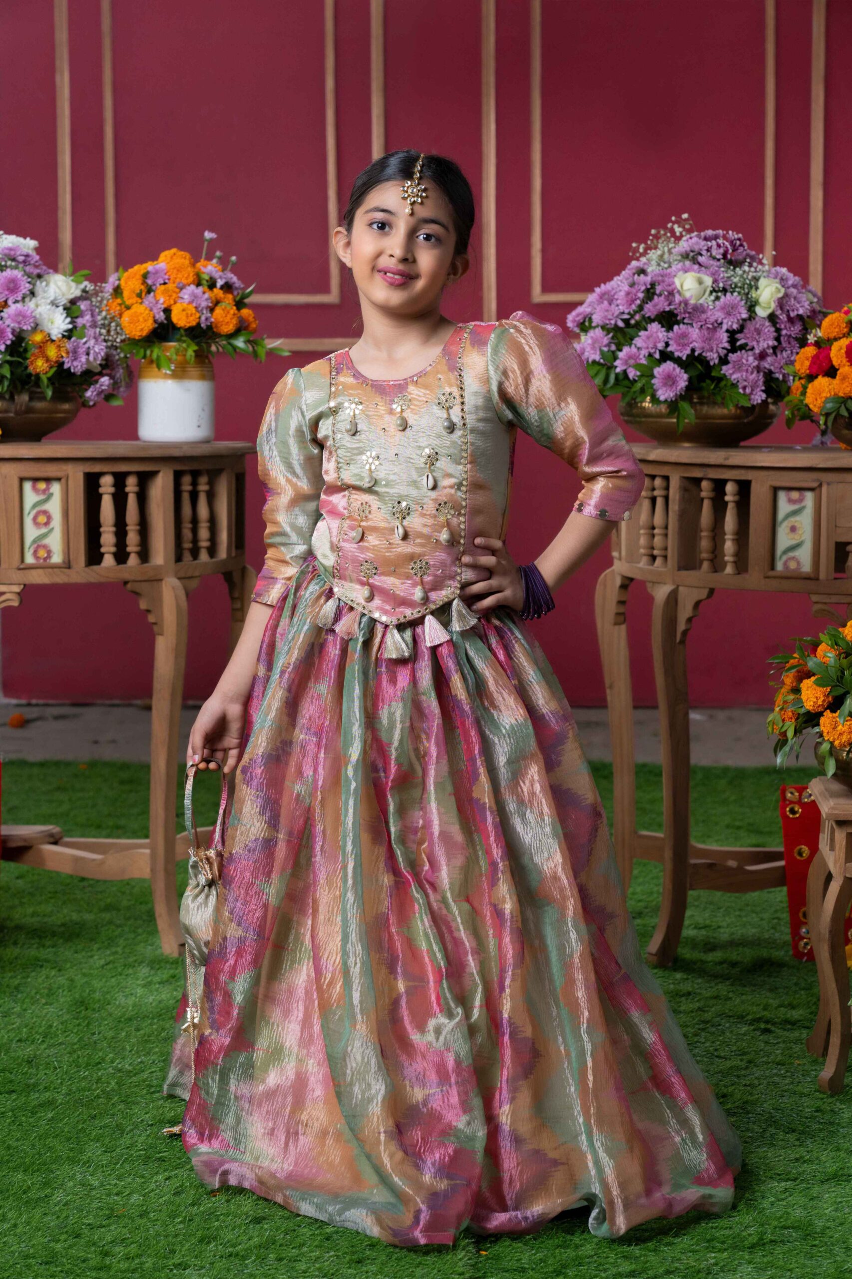 Golden Muslin embroidered lehenga set with a shimmering pastel metallic skirt and matching potli bag.