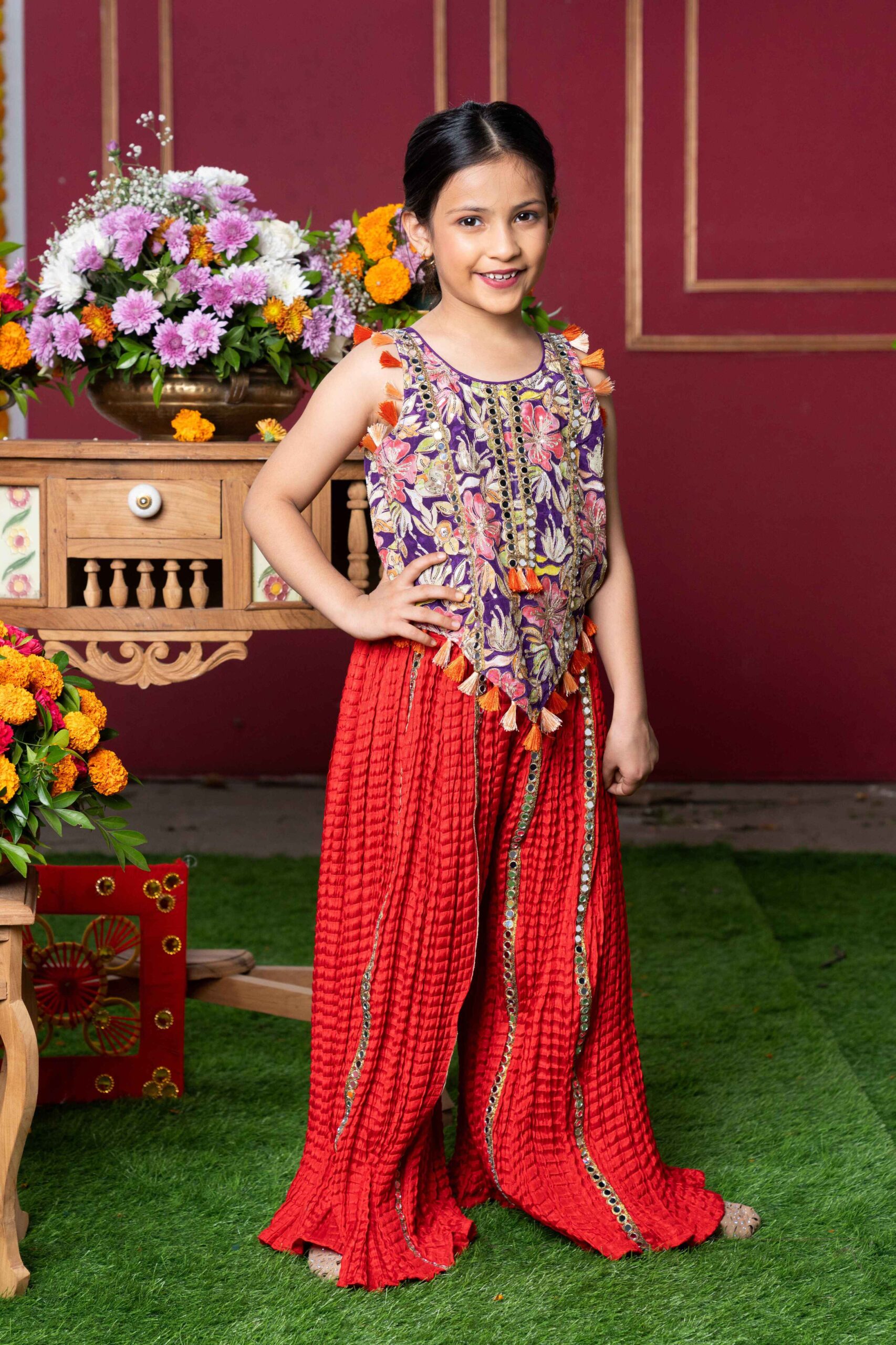 GGolden Muslin girls' purple and red embroidered sharara set with mirror work and tassel details.