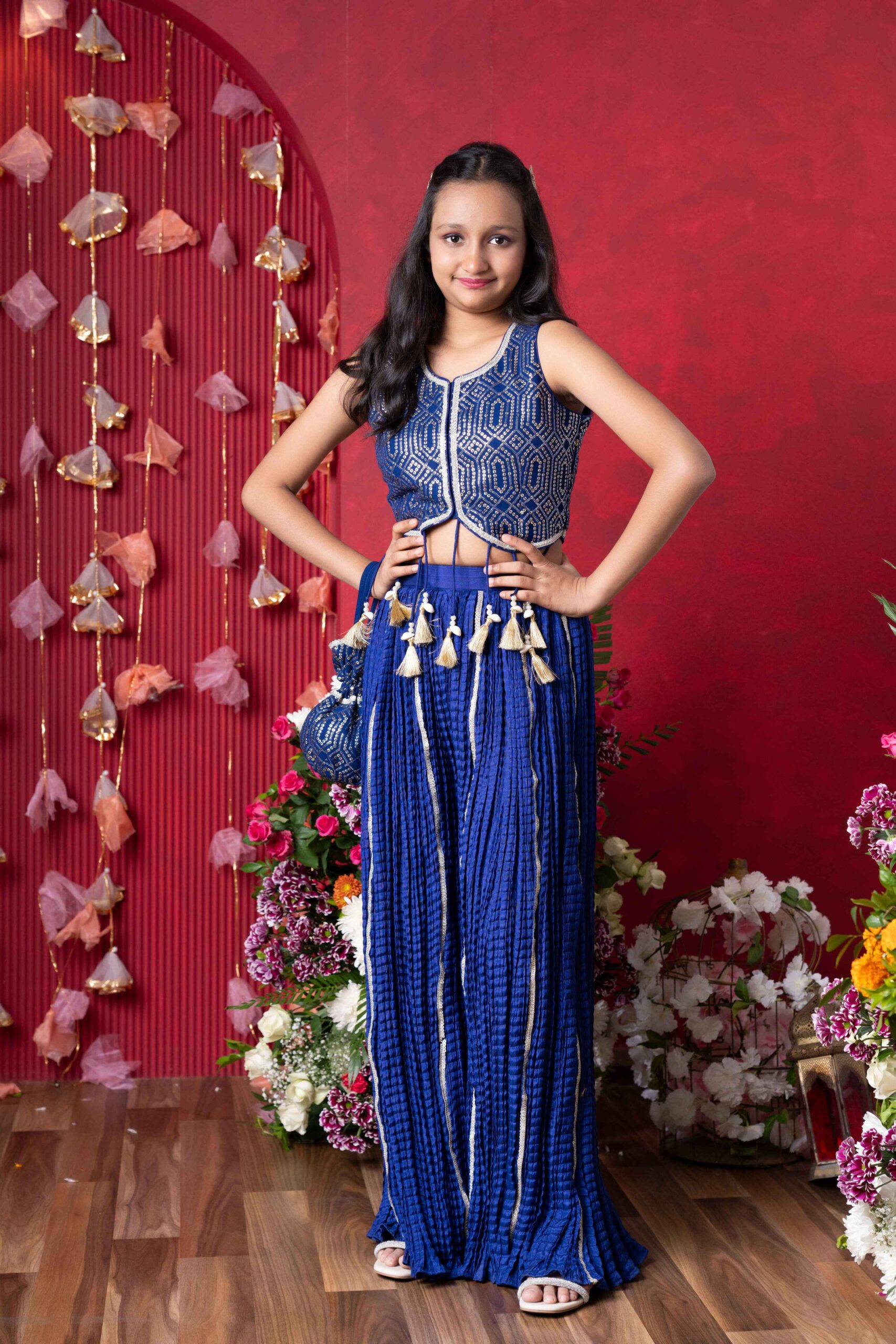 Royal blue girls’ sharara set with silver embroidered crop top, golden-accented sharara pants, and matching potli bag – Golden Muslin