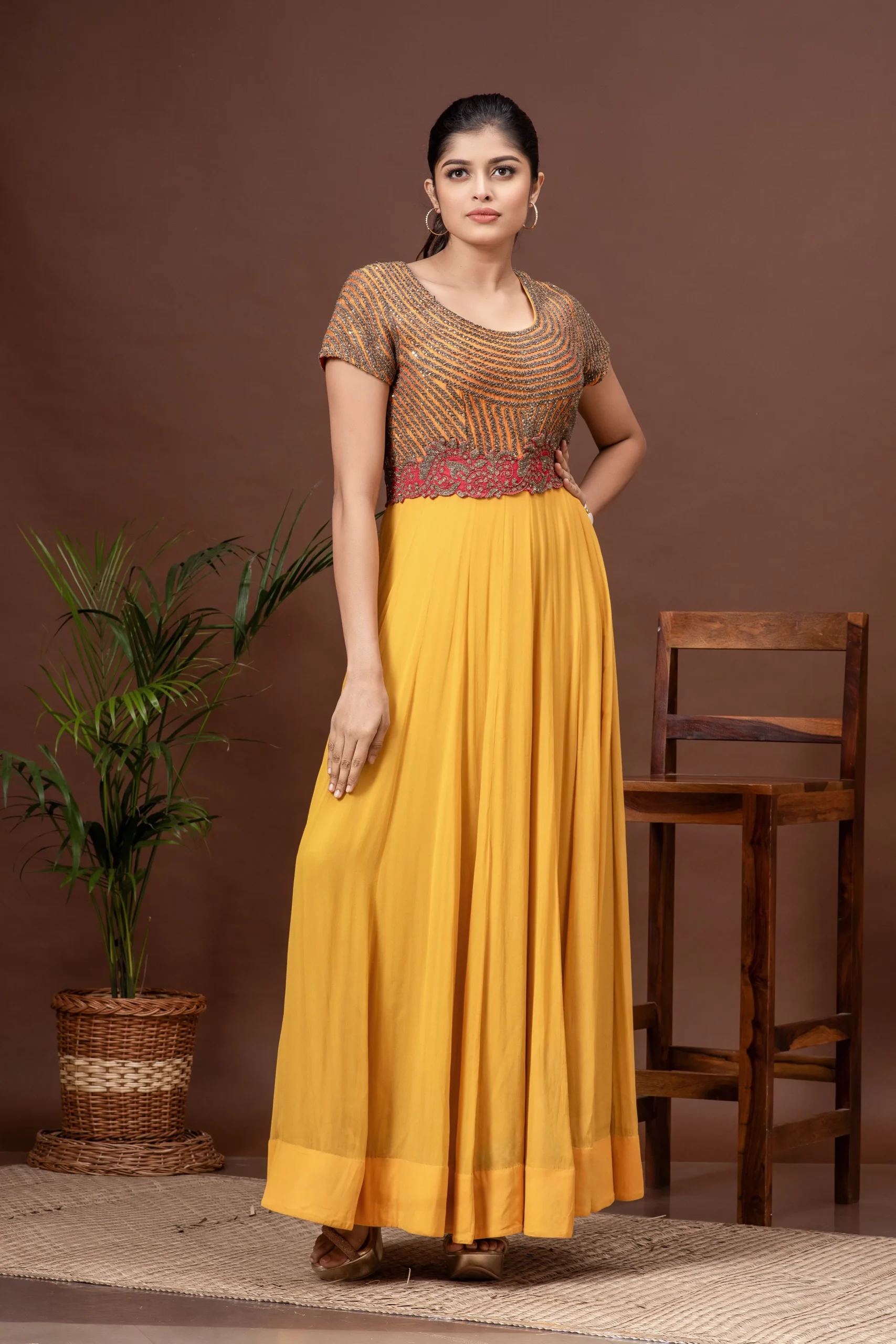 Deep saffron silk and georgette gown with a hand-embroidered yoke from the house of Golden Muslin by Kumar Rahul.