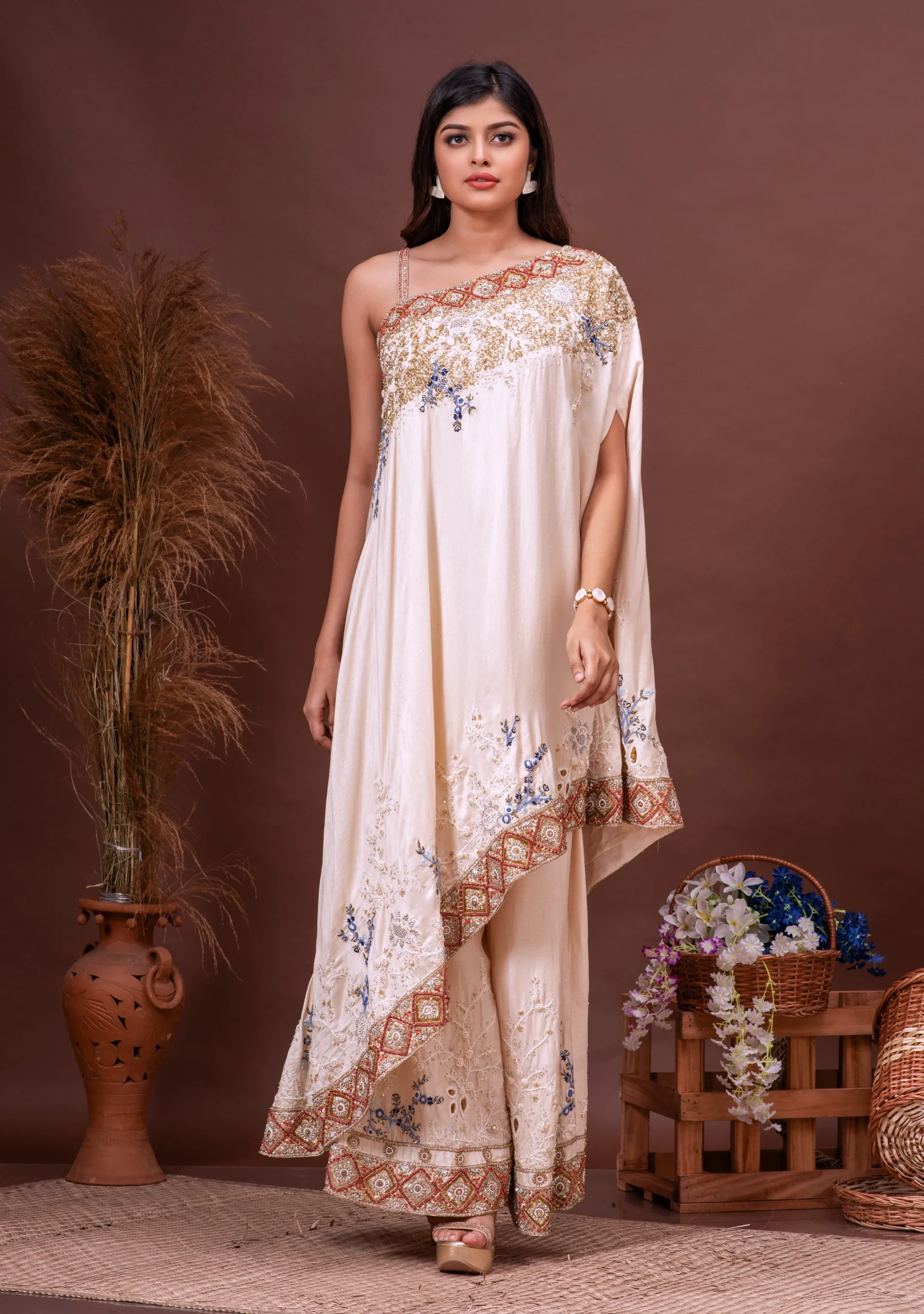 Beige Bamberg silk asymmetric cape and sharara from the house of Golden Muslin by Satya JB with floral sequins.