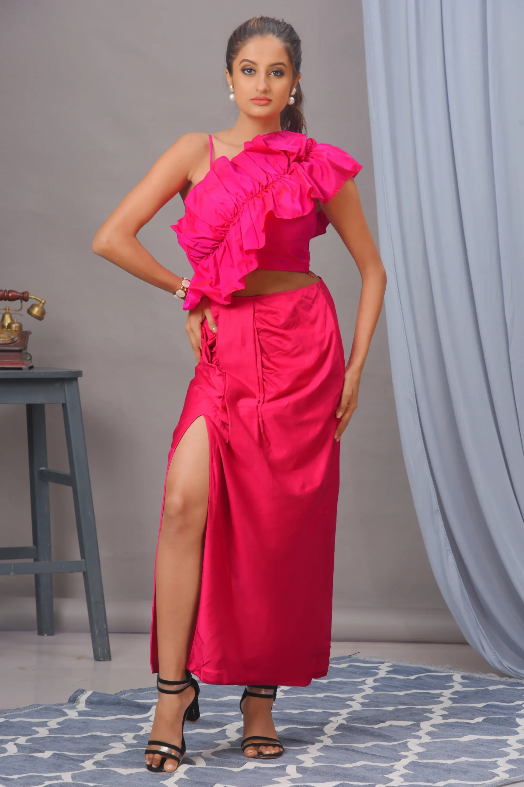 A fuchsia pink ruffled bustier in blended cotton with a front-slit draped skirt by Satya JB from the house of Golden Muslin.