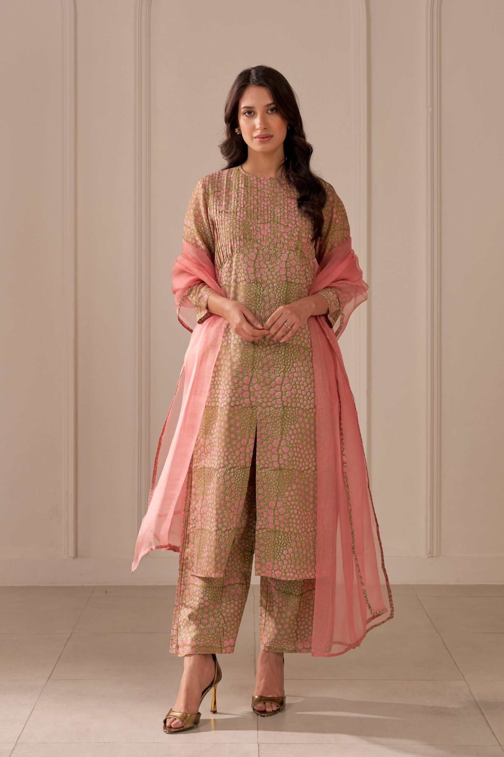 “Golden Muslin olive green mandi block-printed straight kurta with pin tucks, paired with wide-leg Chanderi pants with side pleats and blush pink organza dupatta with mandi block print.”