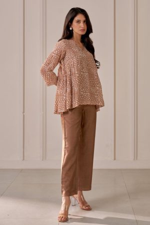 “Golden Muslin brown muslin silk pleated V-neck top with floral block print, paired with matching straight-leg tailored trousers.”