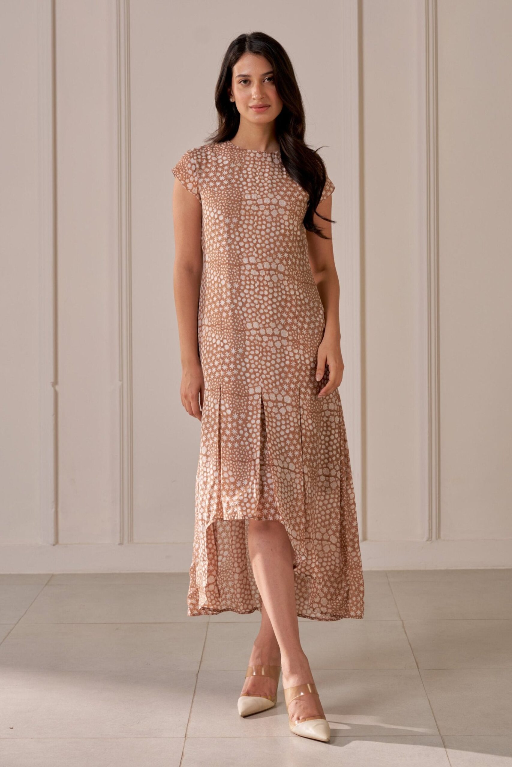 “Golden Muslin asymmetric brown muslin silk dress with mandi block print, cap sleeves, inverted box pleats, and attached lining.”