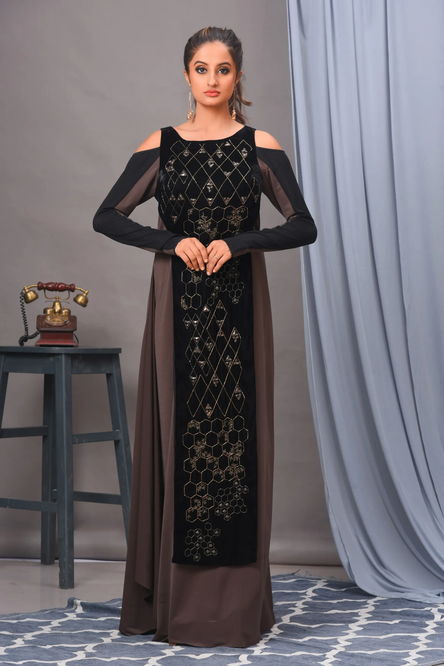 A black and grey full cold-shoulder gown from Golden Muslin By Vivek Kumar, crafted in velvet and spandex with antique gold hand embroidery.