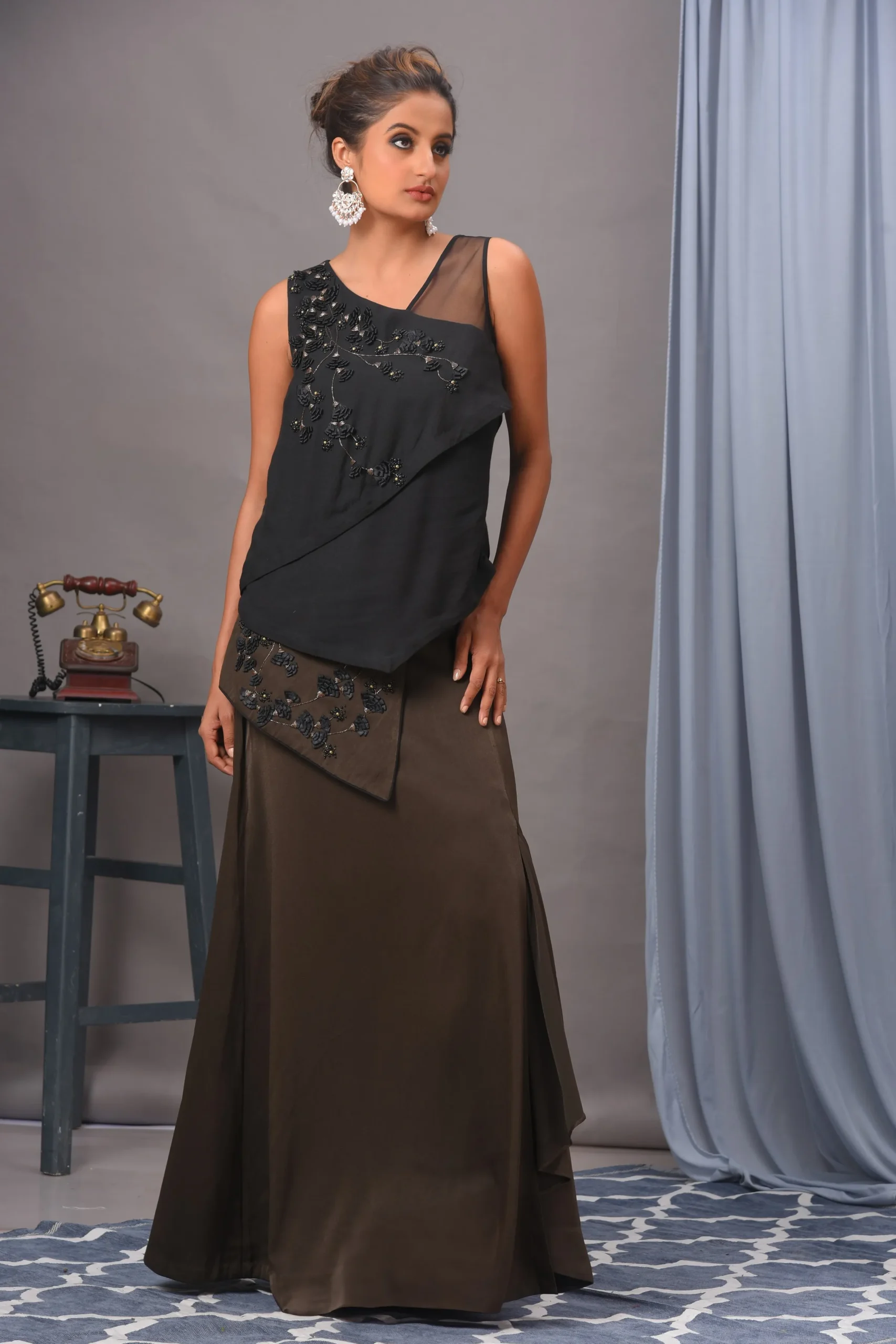 Exquisite black and olive green double georgette and satin skirt set from Golden Muslin By Vivek Kumar featuring a crisscross sleeveless top and embellished overlap skirt.