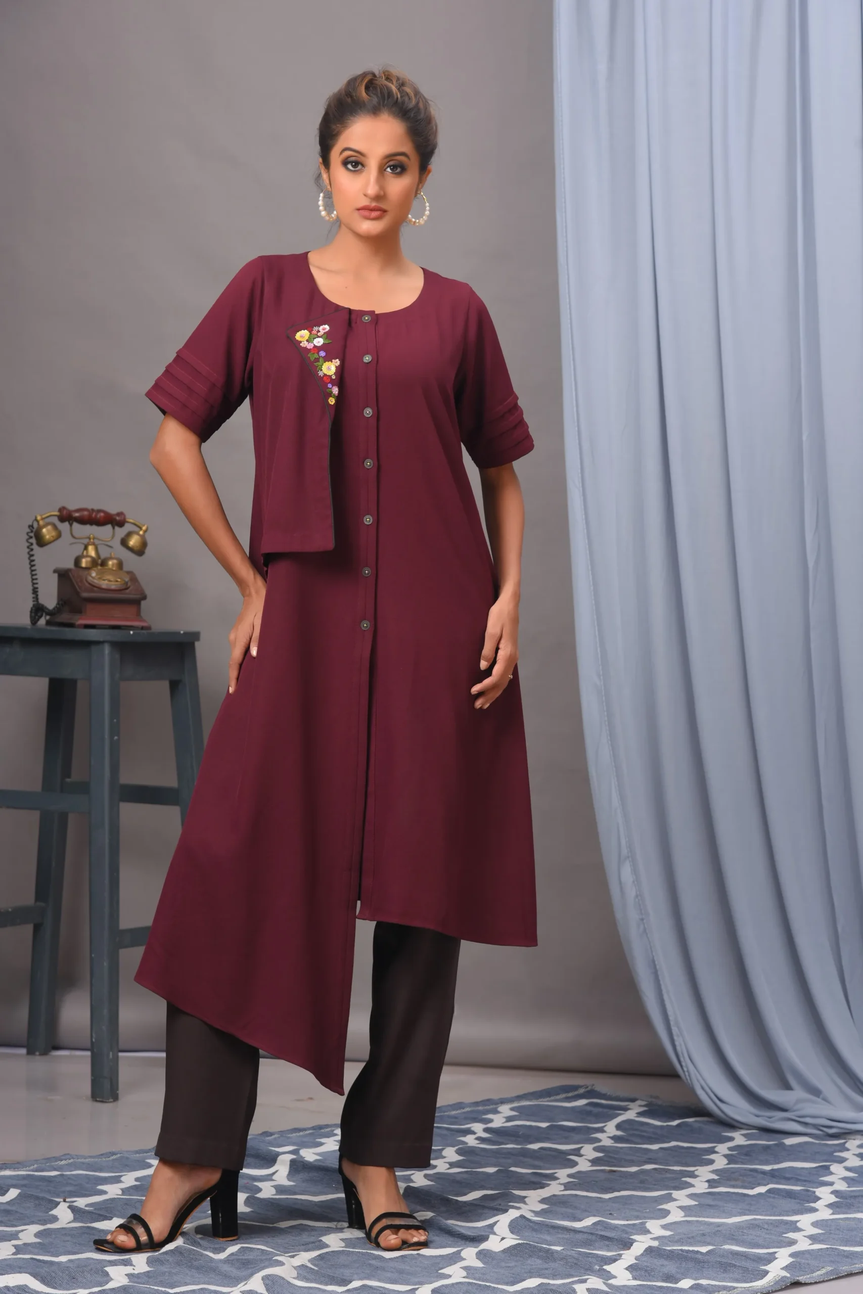 Wine moss crepe asymmetric tunic by Vivek Kumar from Golden Muslin, featuring hand embellishments and pleats, paired with coffee pants.