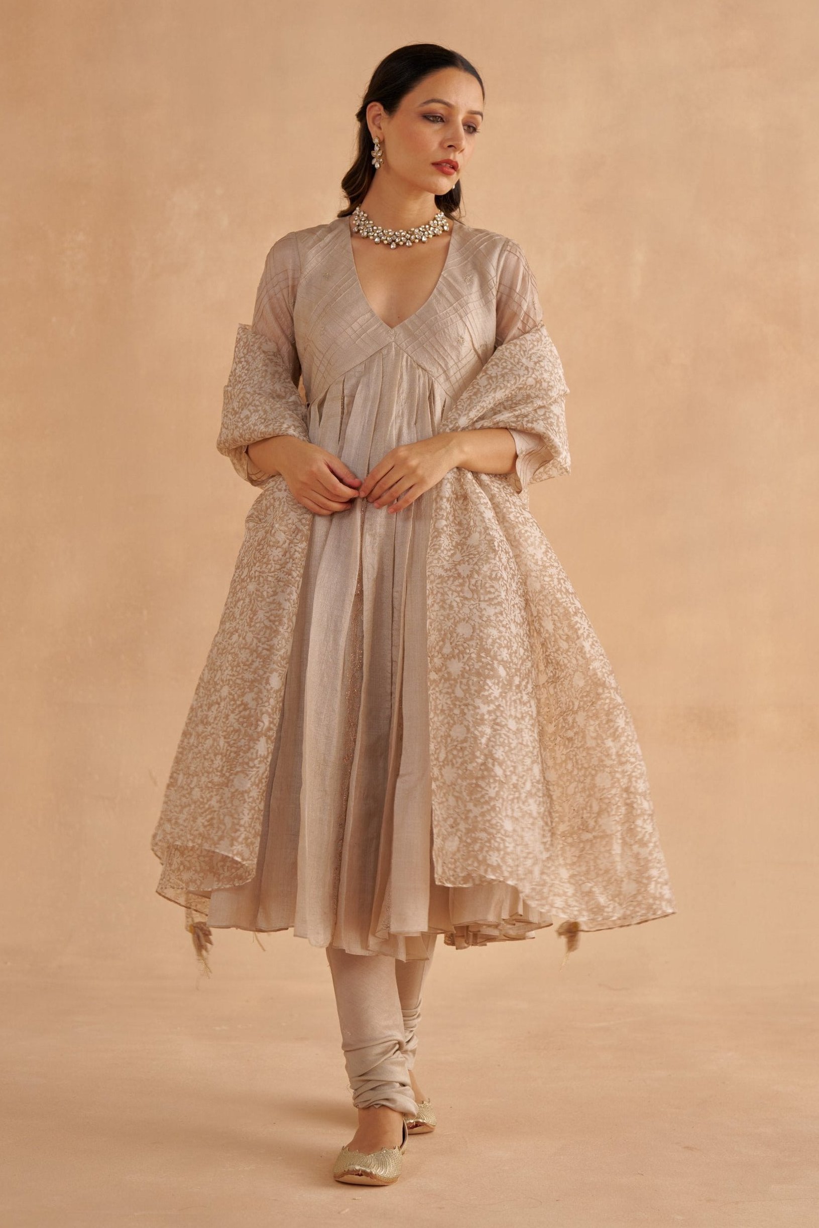 Golden Muslin warm Paper Tussar Kalidar kurta with pin-tuck checks, embroidered motifs, zardozi bels, paired with grey Chanderi churidar and block-printed organza dupatta.