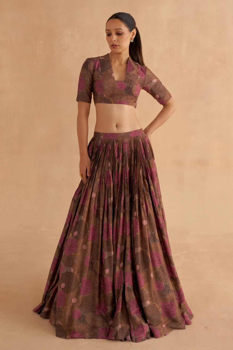 “Golden Muslin walnut brown Moonga silk lehenga set with stylized V-neck printed blouse and fagoting-stitched panels.”