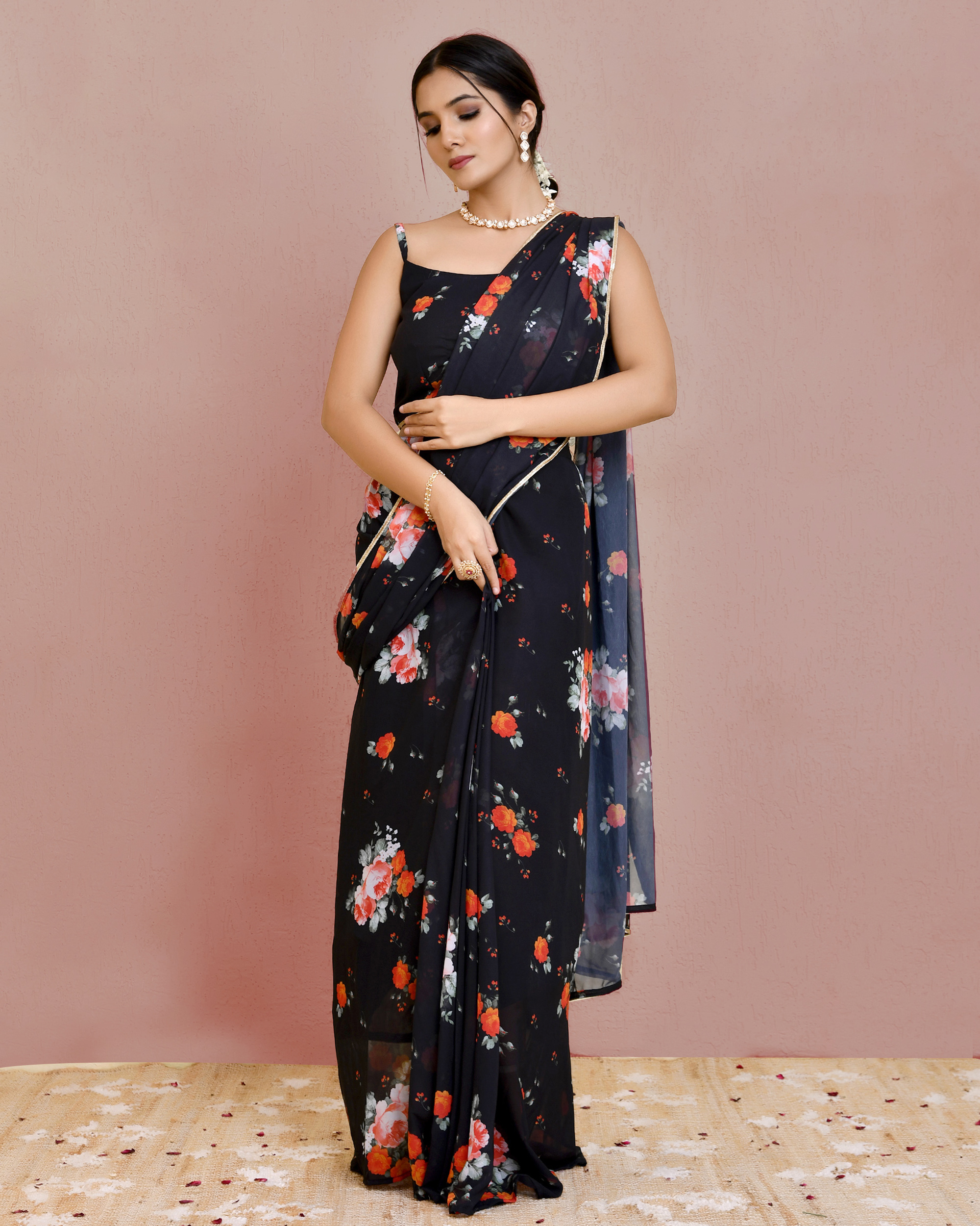 Black pre-draped floral printed georgette saree with lace border detailing and sleeveless blouse in Golden Muslin by Priyanka Rathore