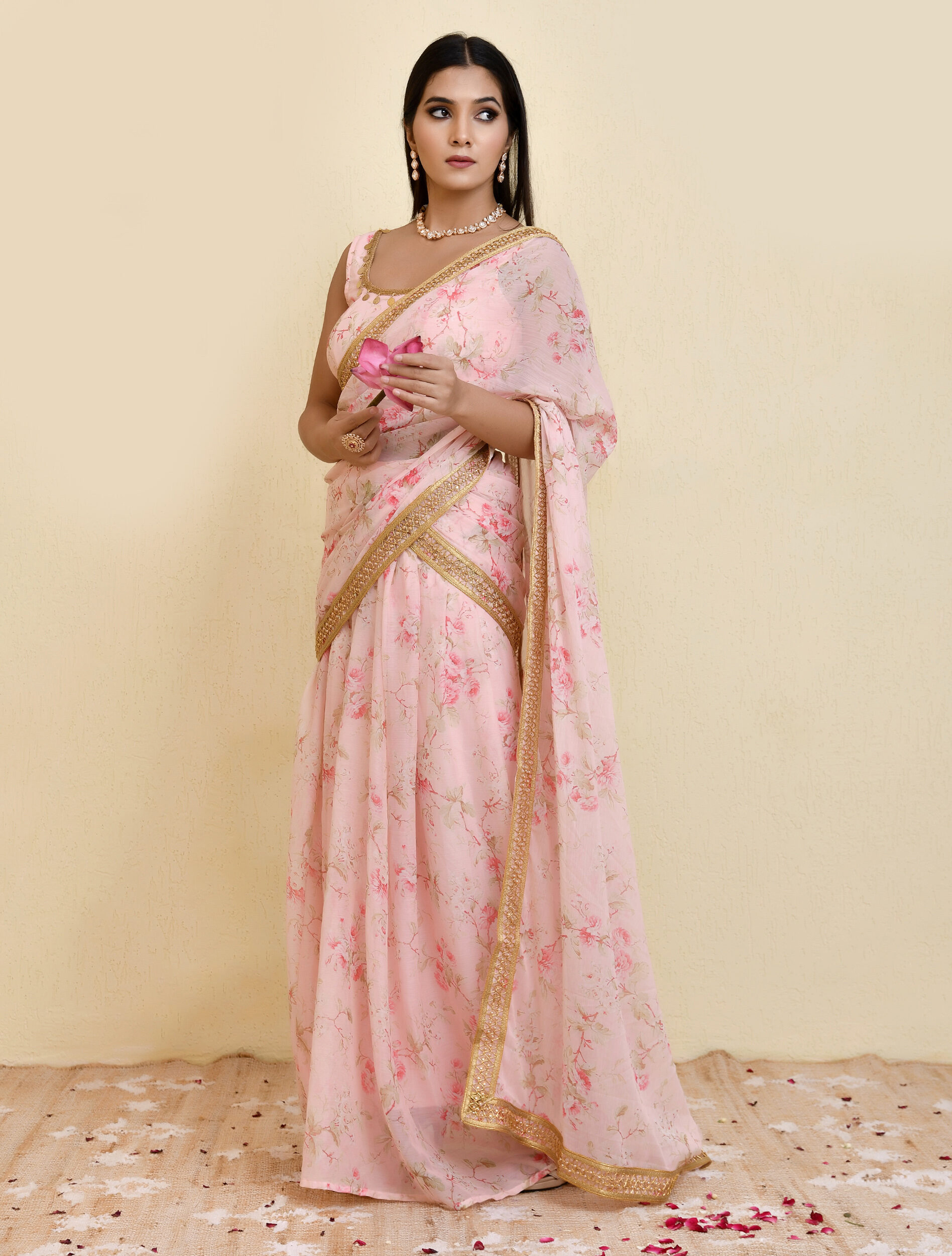 Pink pre-draped floral printed georgette saree with lace border detailing and sleeveless blouse featuring lace neckline and elasticated back in Golden Muslin by Priyanka Rathore