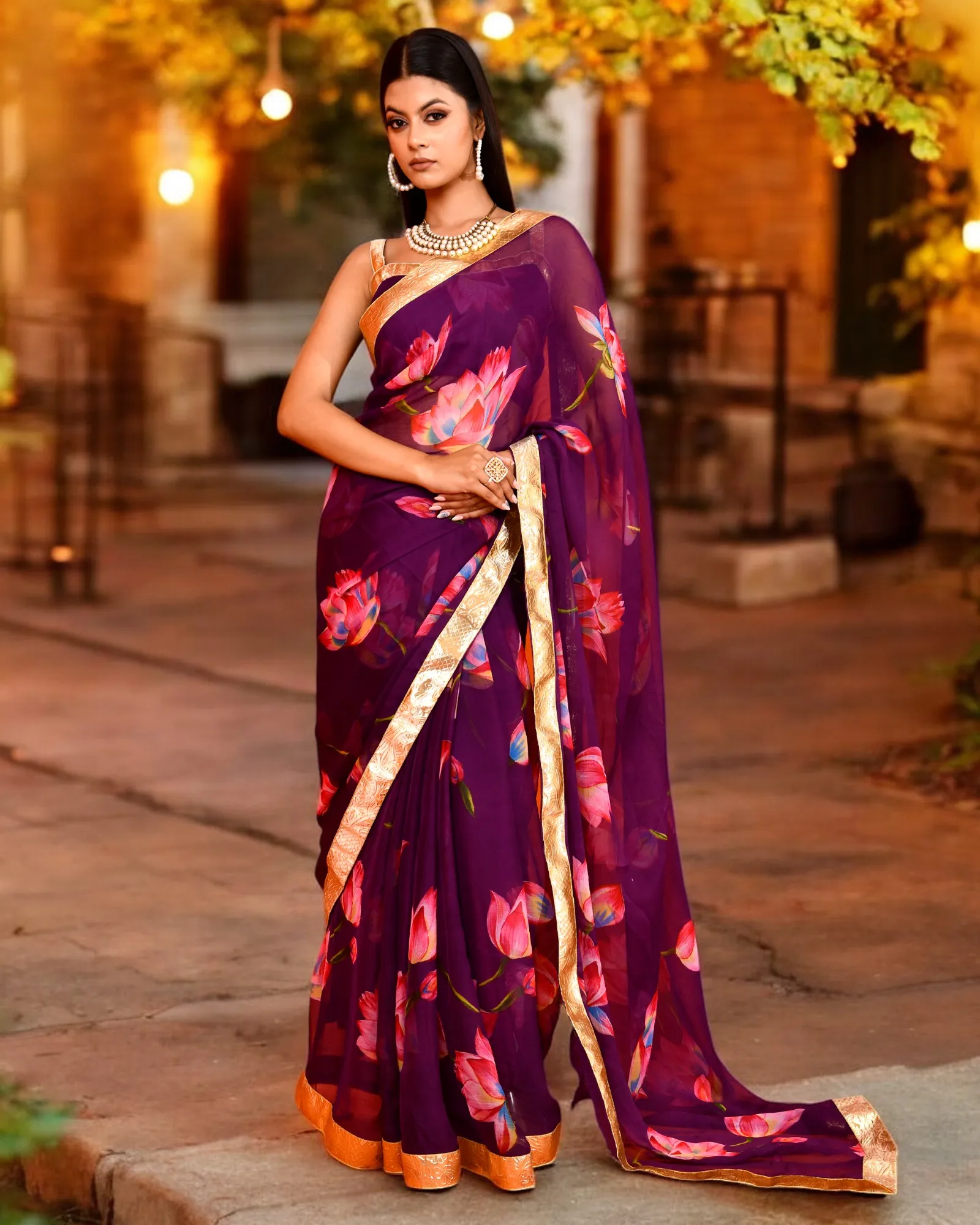 A graceful purple chiffon saree featuring delicate lotus prints and a fluid drape from Golden Muslin by Priyanka Rathore, designed for elegant festive celebrations.