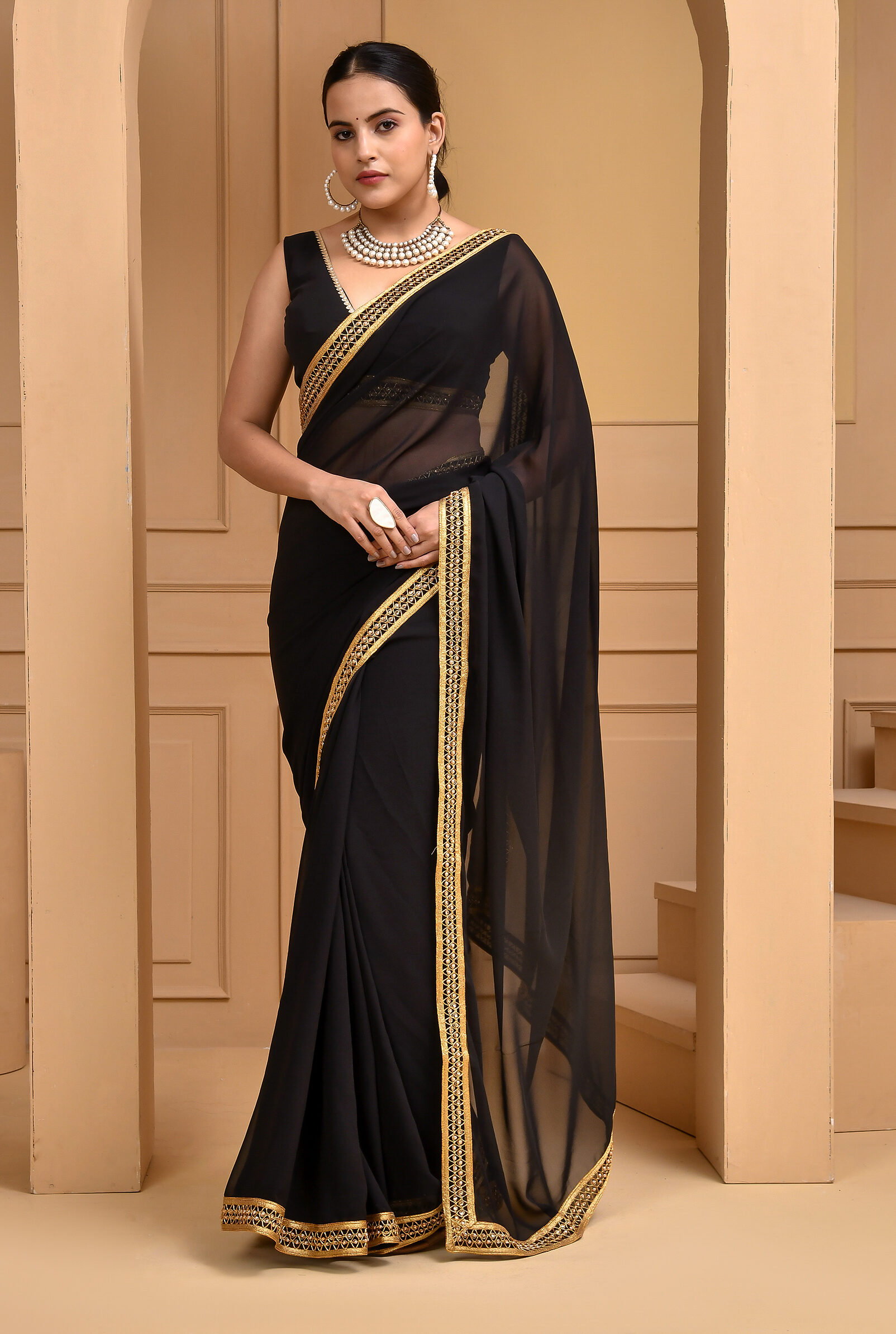 Golden Muslin black georgette saree with intricate lace work borders by Priyanka Rathore