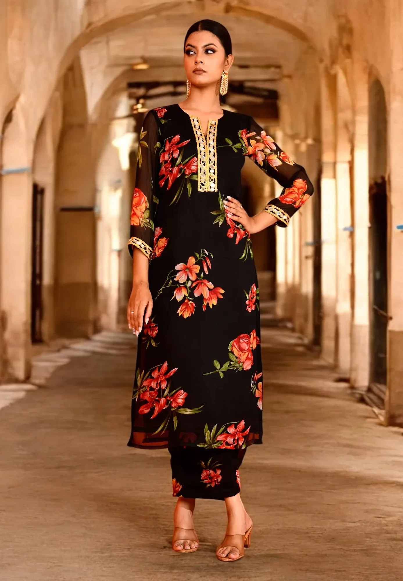 An elegant black chiffon kurta set featuring warm floral prints and a fluid drape from Golden Muslin by Priyanka Rathore, perfect for modern ethnic styling.