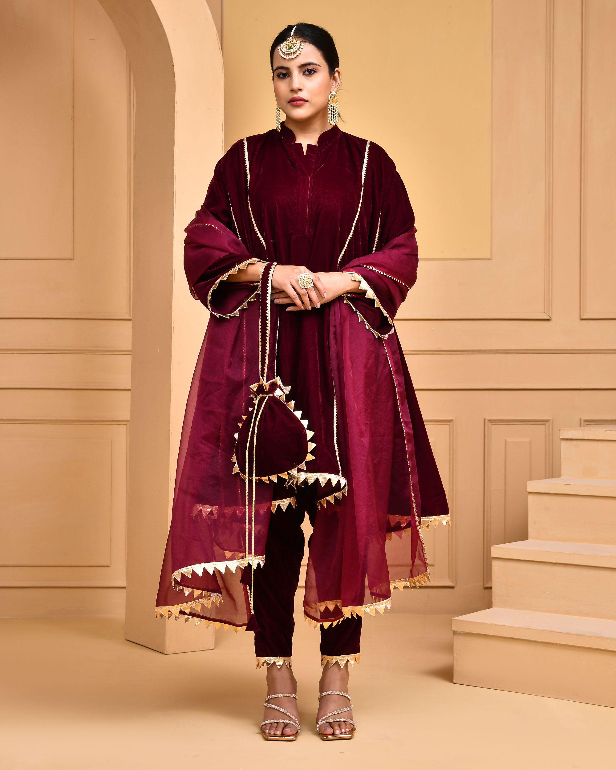 Wine velvet kurta set in Golden Muslin by Priyanka Rathore with gota lace detailing, organza dupatta, and coordinating potli