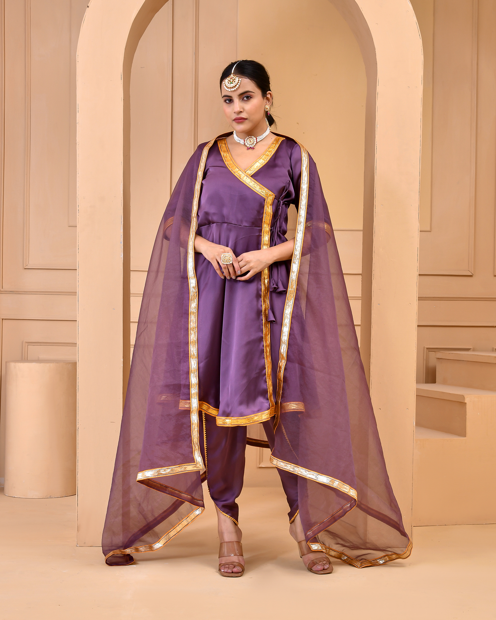 Purple satin silk kurta with dhoti set by Golden Muslin by Priyanka Rathore featuring an angrakha-style kurta with gota lace accents, matching dhoti pants, and a sheer organza dupatta