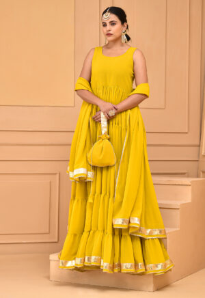 Yellow georgette Anarkali set by Golden Muslin by Priyanka Rathore featuring a flared tiered silhouette with gota detailing, paired with matching dupatta and potli