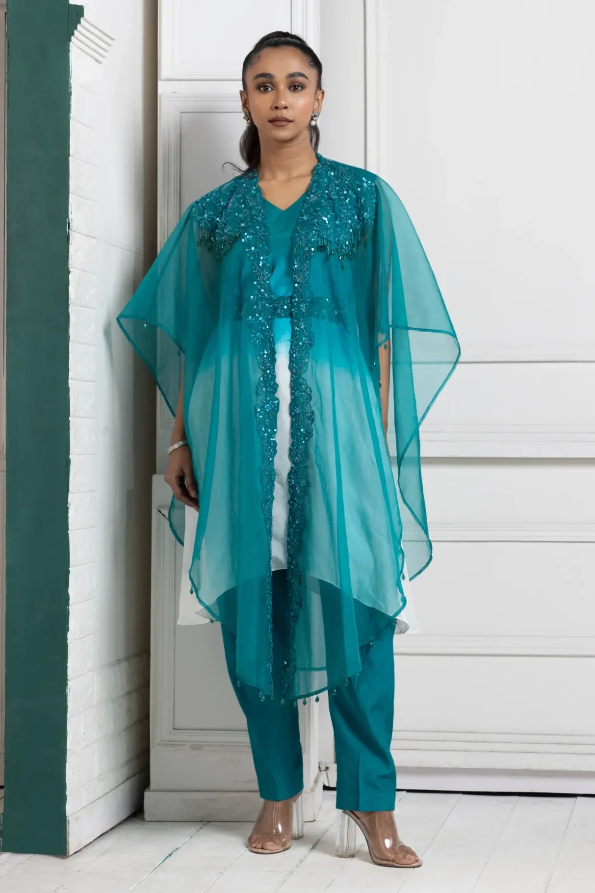 Teal organza embroidered three-piece cape set with tunic and trousers from Golden Muslin By Anuj Agarwal
