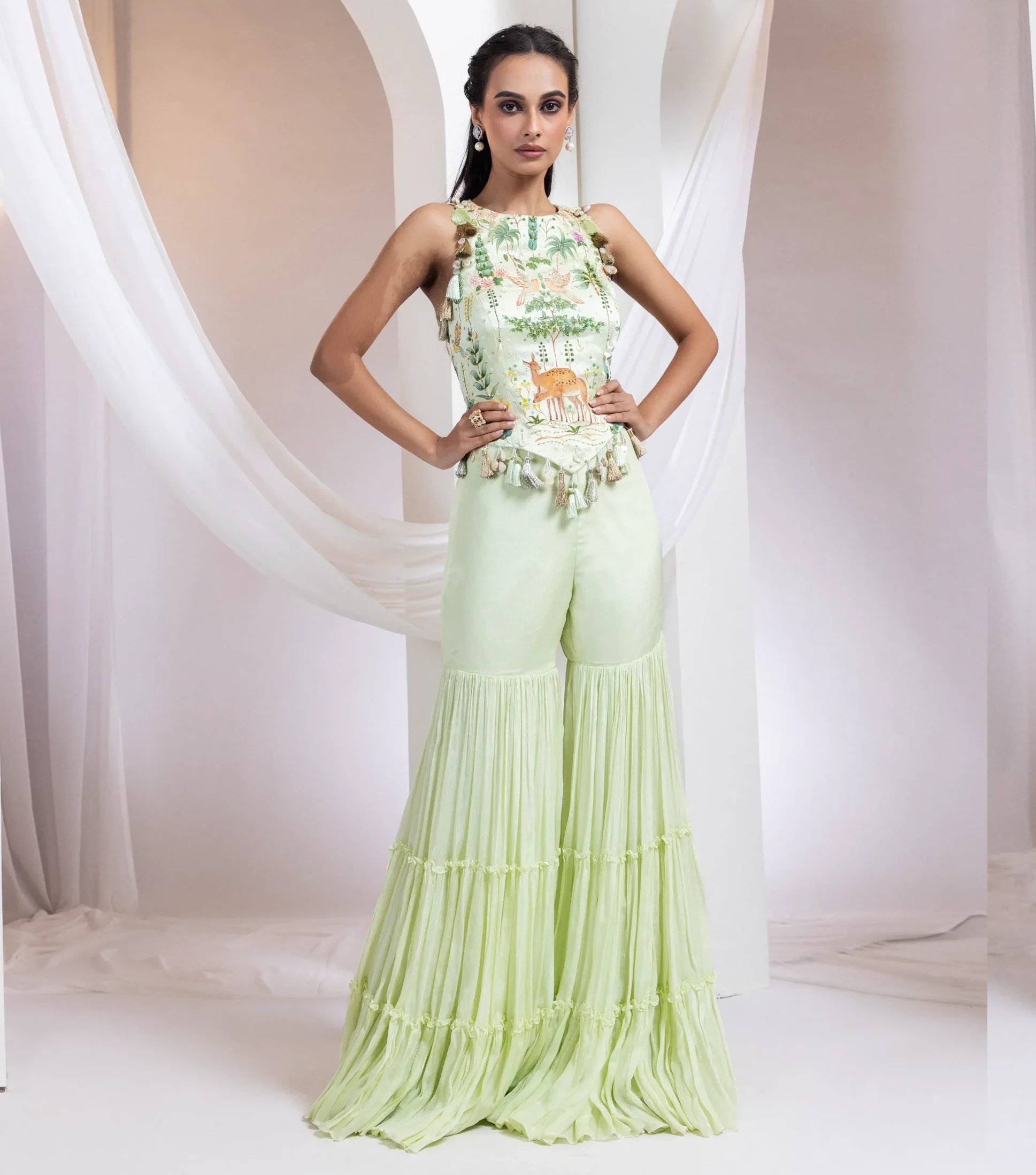Light lime green hand-painted corset with birds and deer paired with flared pants from Golden Muslin By Anuj Agarwal