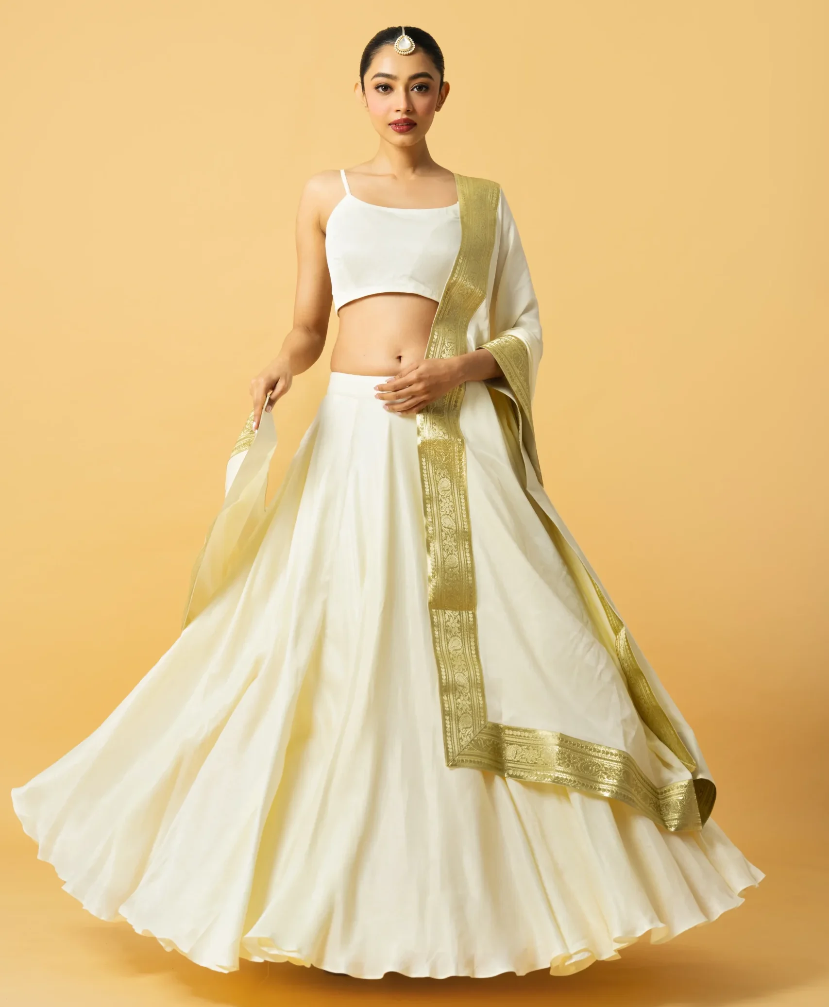 Ivory Modal Satin Lehenga with sleeveless blouse and golden lace dupatta from Golden Muslin By Quench A Thirst