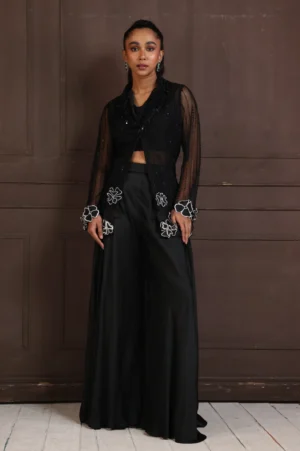 Model wearing black golden muslin bold evening co ord set with sheer panel bodice and wide leg palazzo trousers