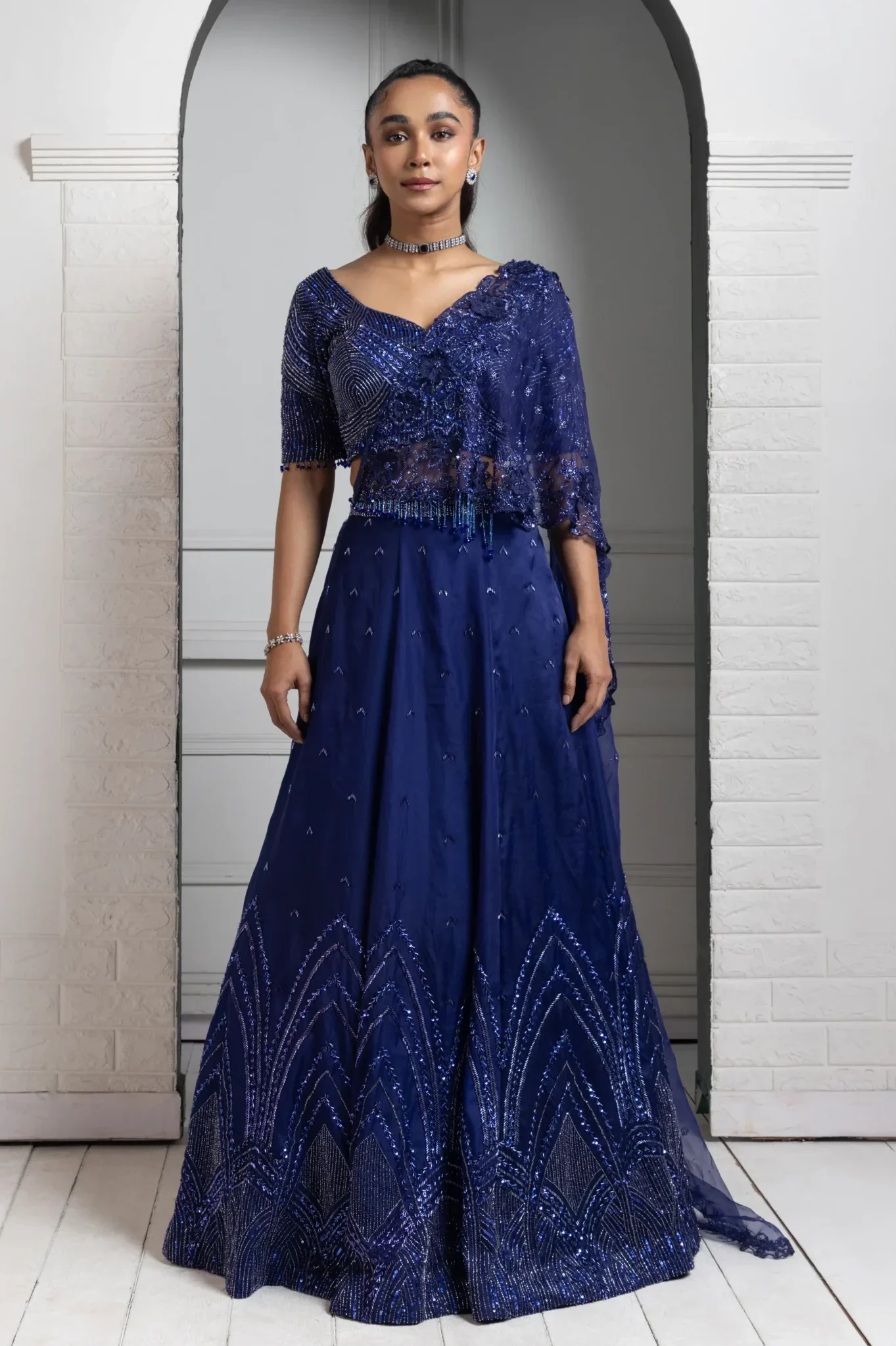 Model wearing deep blue golden muslin sequin and beadwork lehenga set with sheer dupatta
