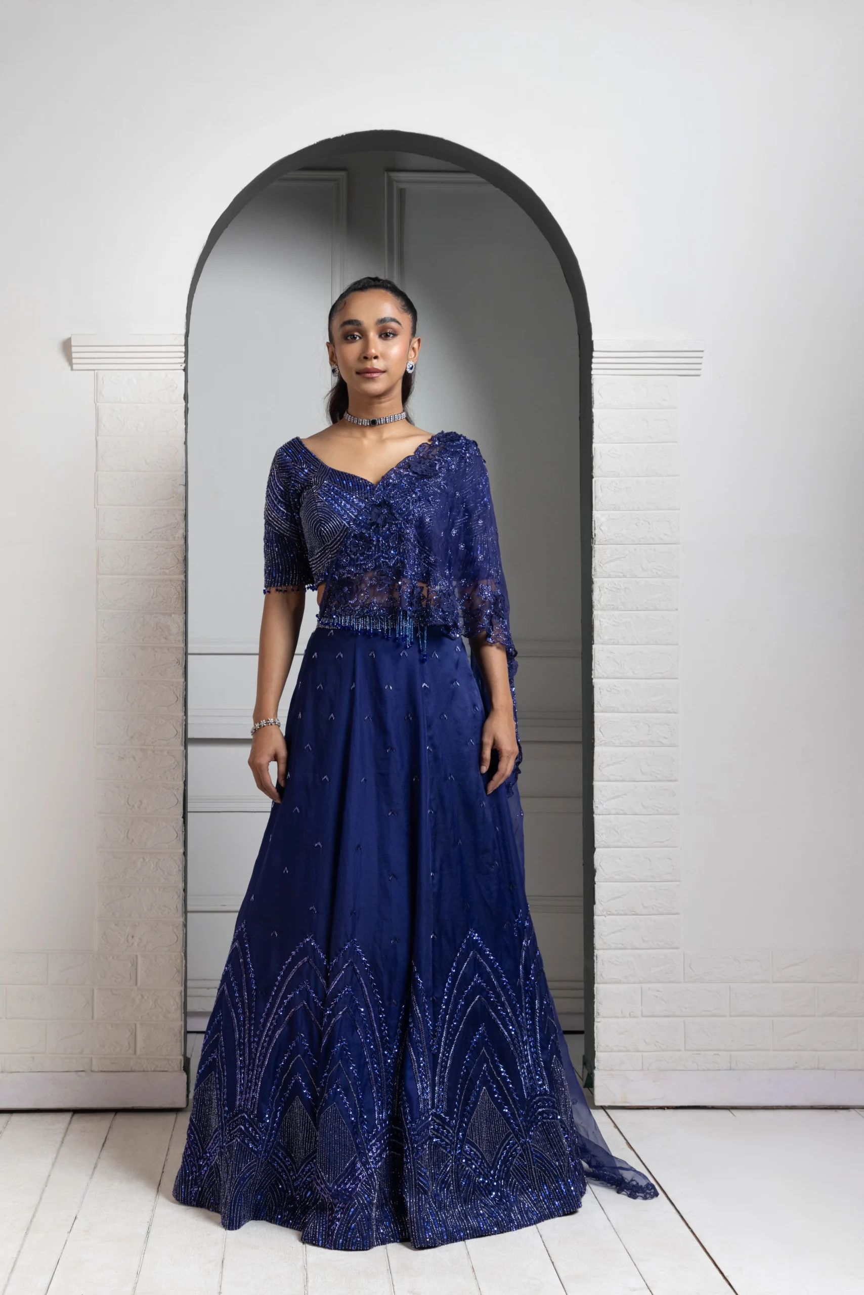 Model wearing deep blue golden muslin sequin and beadwork lehenga set with sheer dupatta
