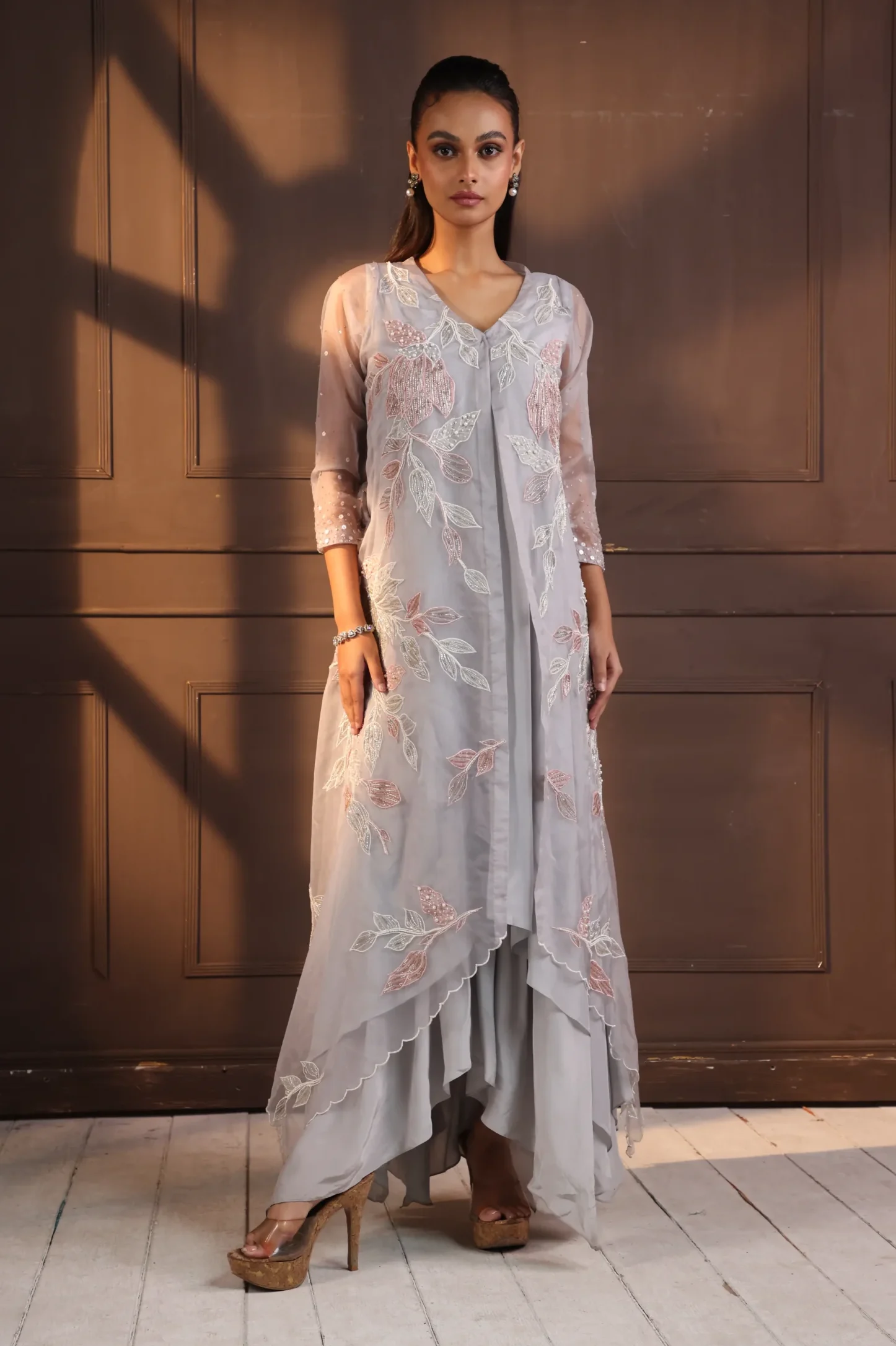 Model wearing grey golden muslin asymmetrical hand embroidered tunic set with floral vine detailing