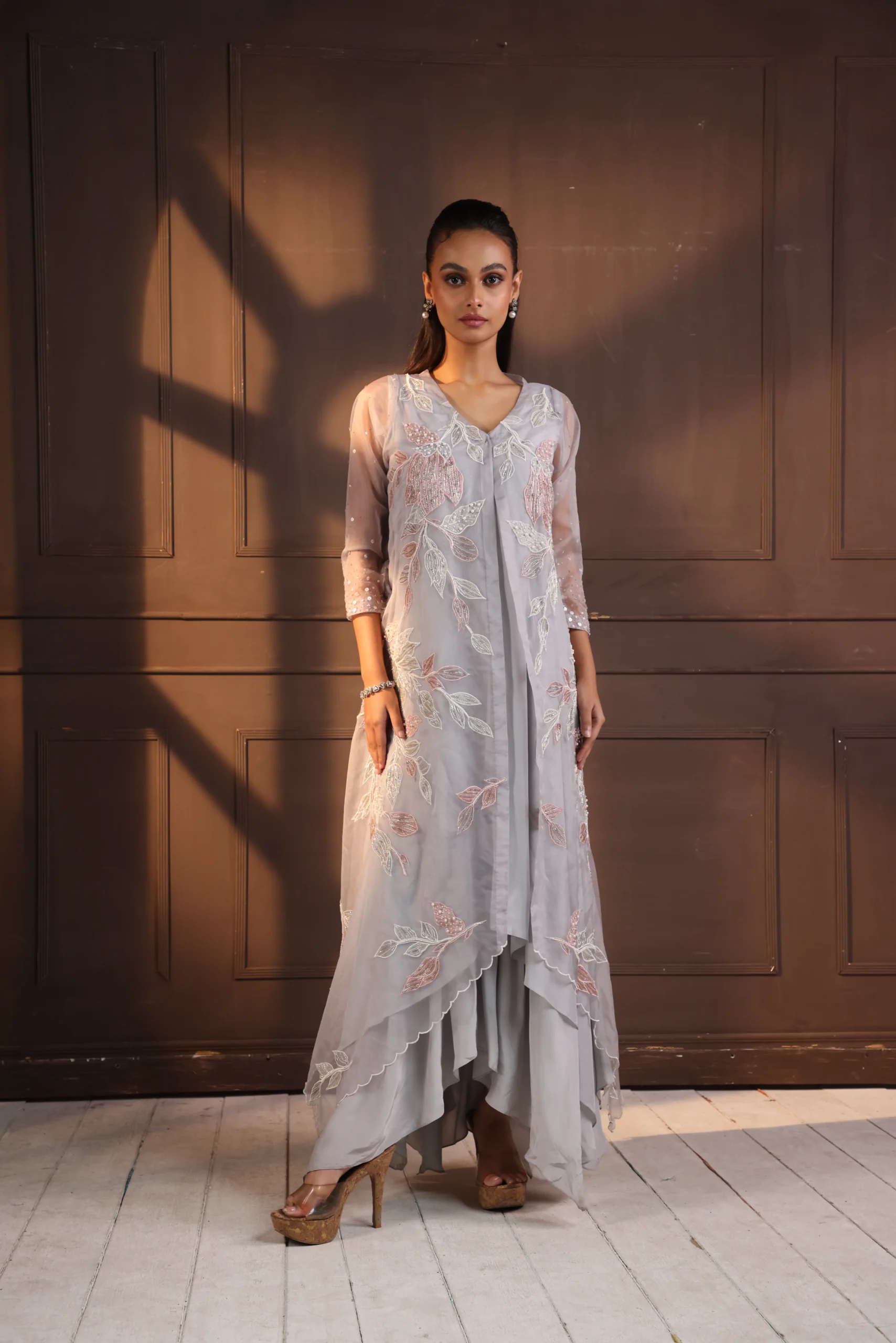 Model wearing grey golden muslin asymmetrical hand embroidered tunic set with floral vine detailing