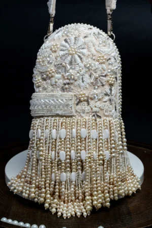 White Beaded Box Clutch with All-Over Tassel Embellishment from Golden Muslin By Nayaab By Sonia featuring intricate beadwork and elegant tassel detailing.