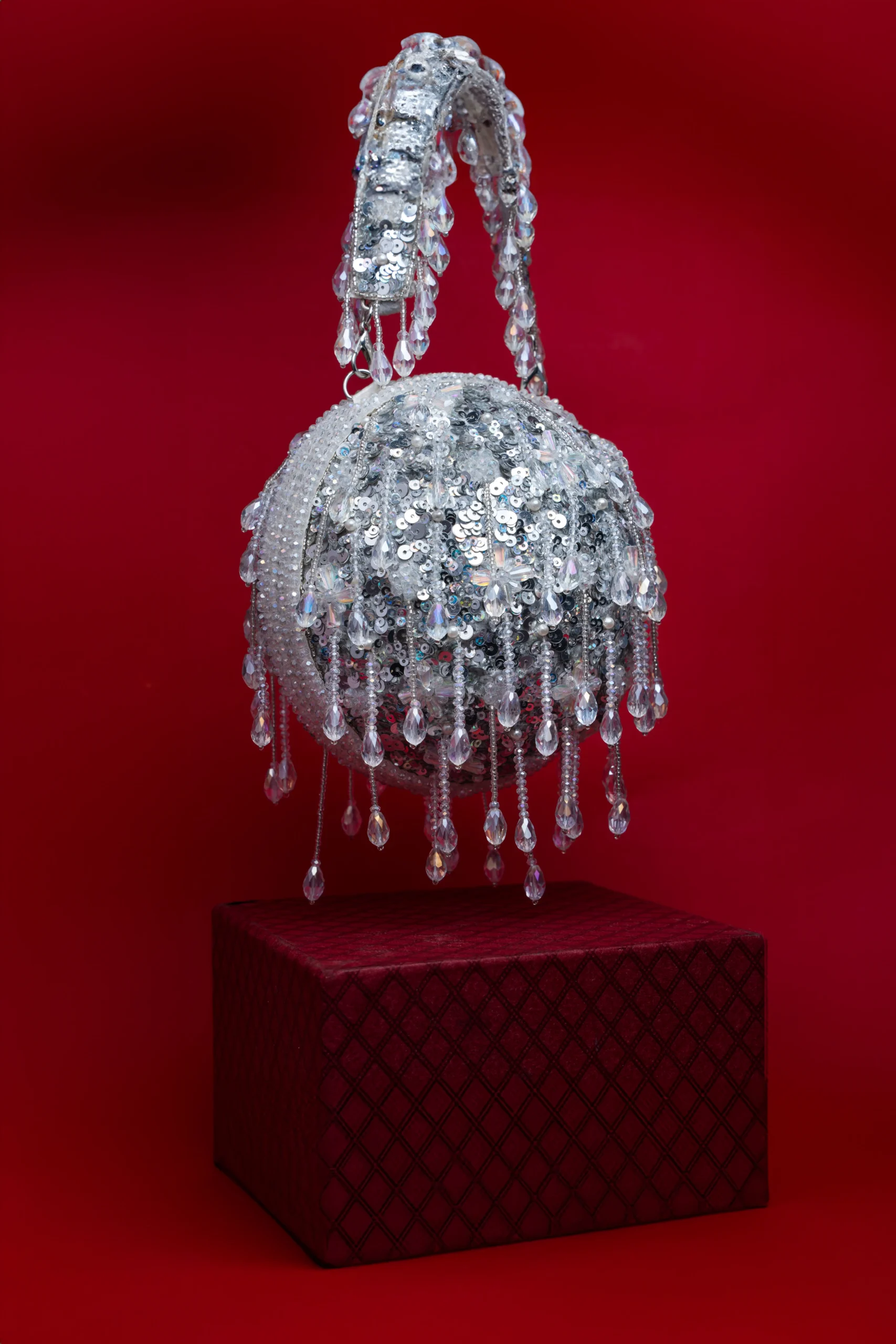 Silver White Beaded Ball Clutch with Shimmering Tassel from Golden Muslin By Nayaab By Sonia featuring intricate beadwork and elegant tassel embellishment.